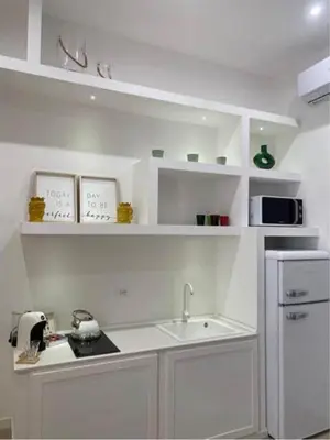 a white kitchen with a sink and a microwave at Sikelia Apartment Centro in Palermo