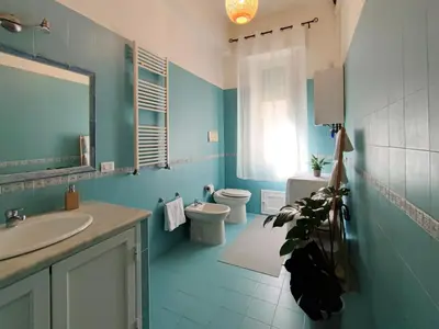 a blue bathroom with a toilet and a sink at ALP House in Palermo