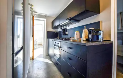 a kitchen with black cabinets and a stove at Nice Home In Balestrate in Balestrate