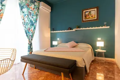 a bedroom with a bed and a blue wall at Libertà #102 - Guest House Palermo in Palermo