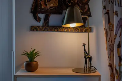 a desk with a lamp and a potted plant on it at Libertà #102 - Guest House Palermo in Palermo