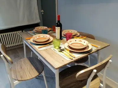 a wooden table with plates and a bottle of wine at Loft 2 in Mondello beach Mt. 200 from sea. in Palermo