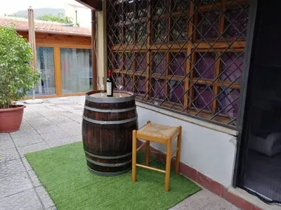 a wine barrel and a stool next to a building at Loft 2 in Mondello beach Mt. 200 from sea. in Palermo