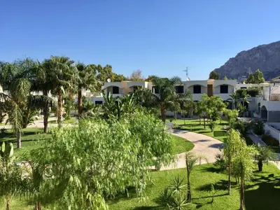 a view of a park with palm trees and buildings at Le Palme House Isola delle Femmine in Isola delle Femmine