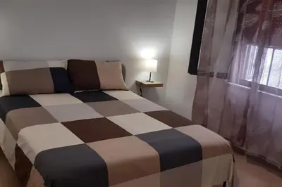 a bedroom with a bed with a checkered patterned sheets at Casa Poseidonia - intero alloggio in riva al mare in Carini