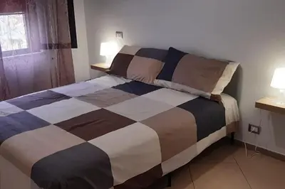 a bed in a room with two lamps on a table at Casa Poseidonia - intero alloggio in riva al mare in Carini