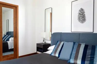 a bedroom with a blue bed and a mirror at Vicolo Paternò Apartments in Palermo