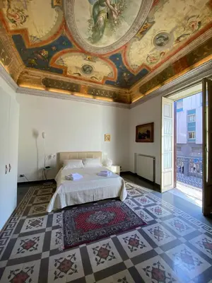 a bedroom with a bed with a ceiling and a rug at Amari 106 in Palermo