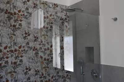 a bathroom with a shower with a mirror at Elimi Home Appartamenti in Nuova Gibellina