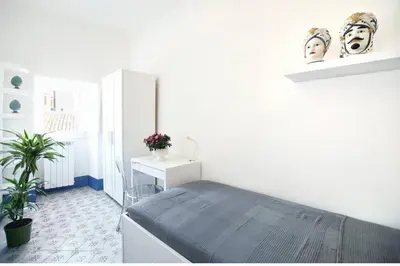 a white room with a bed and a desk at iFlat Dimora del Cassaro in Palermo