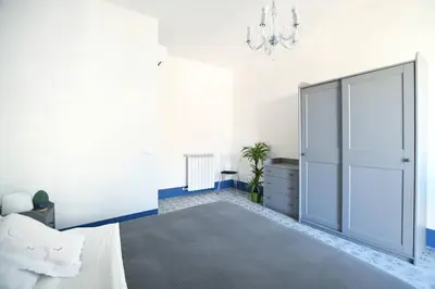 a bedroom with a large bed and a chandelier at iFlat Dimora del Cassaro in Palermo