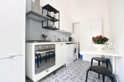 a white kitchen with a stove and a dishwasher at iFlat Dimora del Cassaro in Palermo