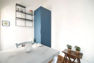 a dining room with a white table and blue cabinet at iFlat agli Archetti del centro in Palermo