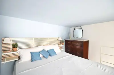 a bedroom with a white bed with blue pillows at iFlat agli Archetti del centro in Palermo