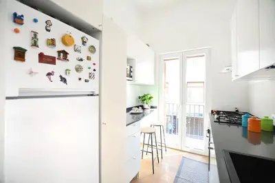 a kitchen with white cabinets and a refrigerator at iFlat Casa Isabella in Palermo
