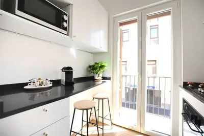 a kitchen with a black counter top and a balcony at iFlat Casa Isabella in Palermo