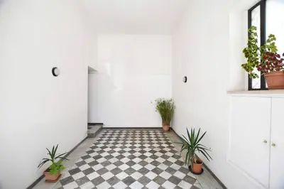 a hallway with potted plants and a checkered floor at iFlat Casa Isabella in Palermo