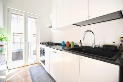 a kitchen with white cabinets and a sink at iFlat Casa Isabella in Palermo